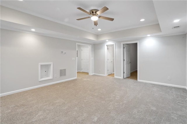 unfurnished room featuring light carpet, crown molding, and a raised ceiling