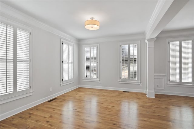 empty room featuring crown molding, light hardwood / wood-style flooring, and a healthy amount of sunlight