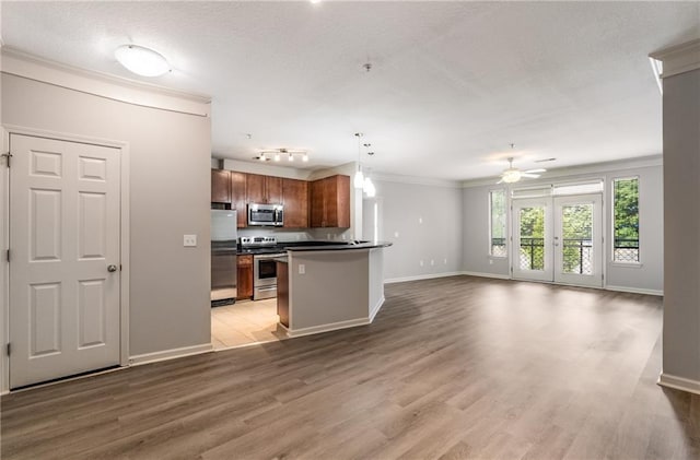 kitchen with hardwood / wood-style floors, decorative light fixtures, stainless steel appliances, ceiling fan, and crown molding