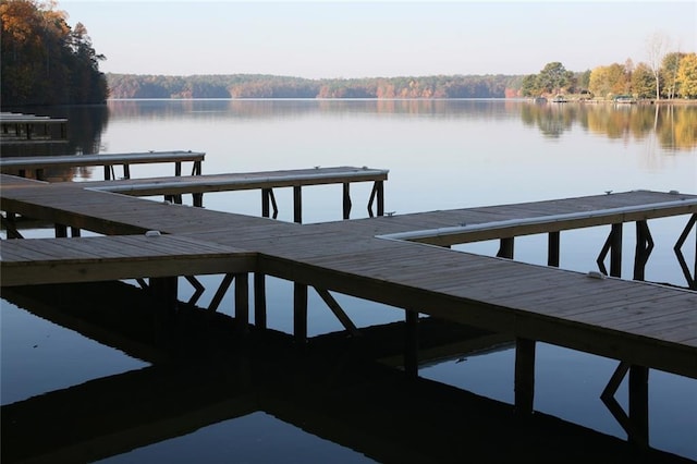 dock area featuring a forest view and a water view