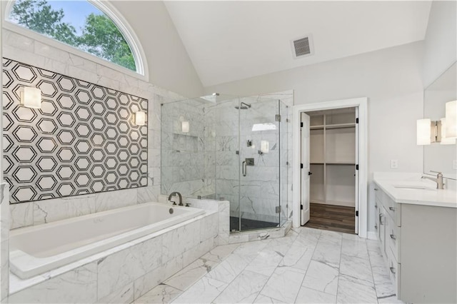 bathroom featuring a garden tub, visible vents, a stall shower, a spacious closet, and lofted ceiling