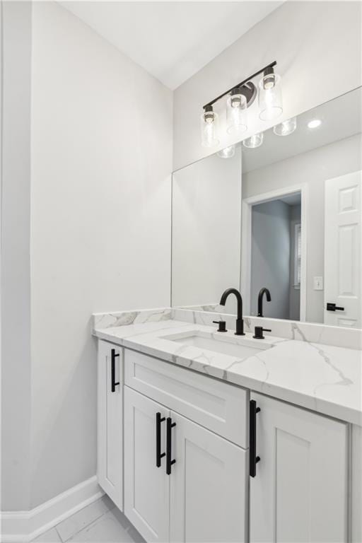 bathroom featuring baseboards, vanity, and marble finish floor
