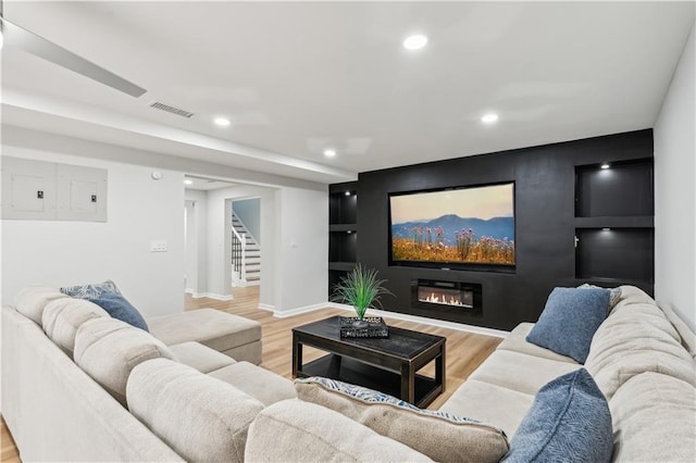 living area featuring recessed lighting, baseboards, wood finished floors, and stairway