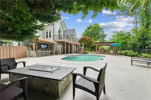 view of pool with fence, outdoor dry bar, a fenced in pool, a patio area, and stairway