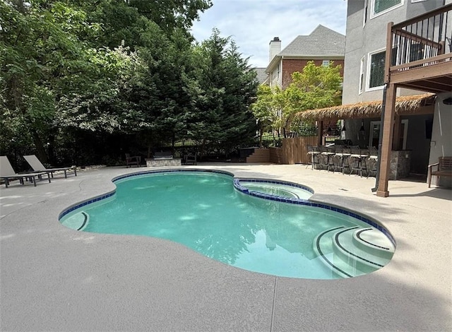 view of swimming pool featuring a patio area, a pool with connected hot tub, and outdoor dry bar