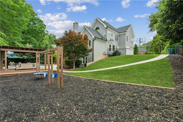 view of play area with a yard, a deck, fence, and a pergola
