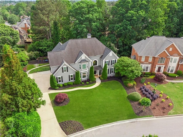 view of front of home featuring stucco siding, driveway, a shingled roof, and a front lawn