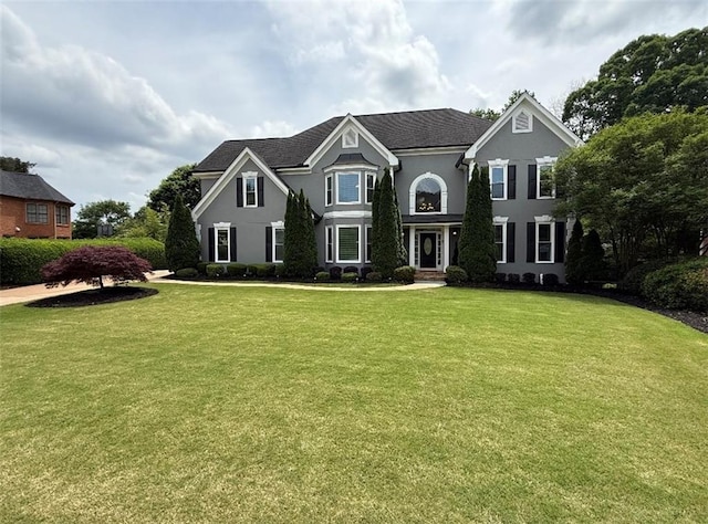 view of front of house featuring stucco siding and a front yard