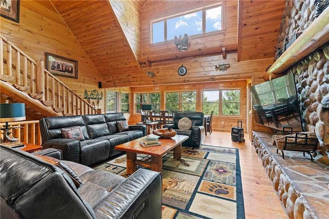 living room with light hardwood / wood-style flooring, high vaulted ceiling, wood ceiling, and wood walls