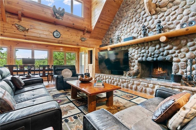 living room featuring wooden walls, a fireplace, high vaulted ceiling, and wooden ceiling