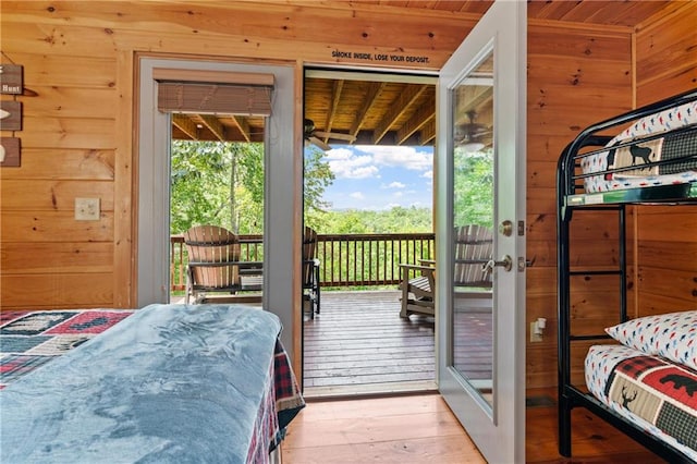 bedroom featuring access to exterior, light hardwood / wood-style flooring, multiple windows, and wooden ceiling