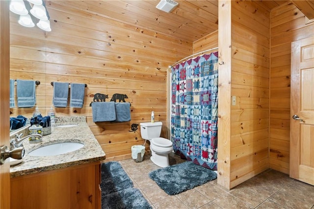 bathroom with tile patterned floors, wood ceiling, vanity, wooden walls, and toilet