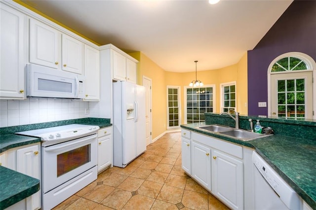 kitchen featuring white appliances, a sink, white cabinets, and dark countertops
