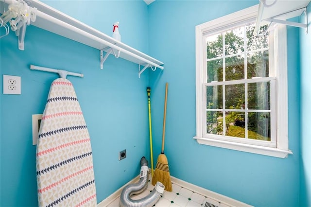 laundry area featuring electric dryer hookup, healthy amount of natural light, and baseboards