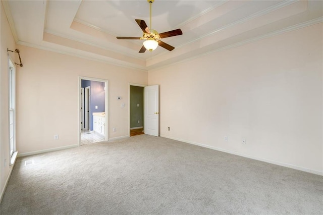unfurnished bedroom with a tray ceiling, carpet, crown molding, baseboards, and ceiling fan