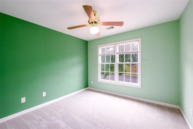 carpeted spare room with baseboards and ceiling fan