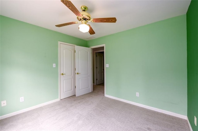 unfurnished bedroom featuring light colored carpet, baseboards, and ceiling fan