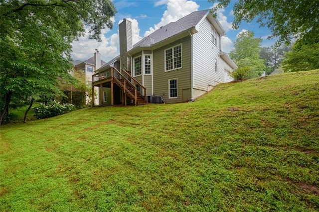 rear view of house with stairway, a chimney, a wooden deck, a lawn, and central air condition unit