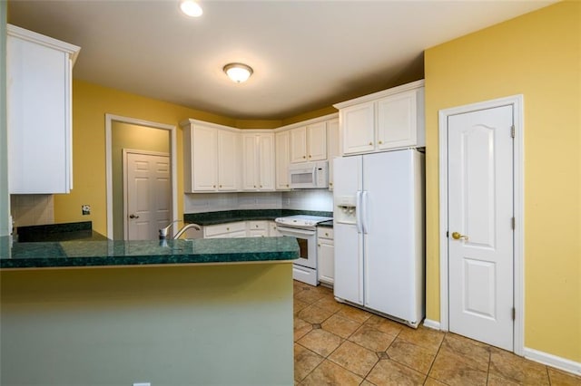 kitchen featuring white appliances, a peninsula, white cabinets, light tile patterned flooring, and tasteful backsplash