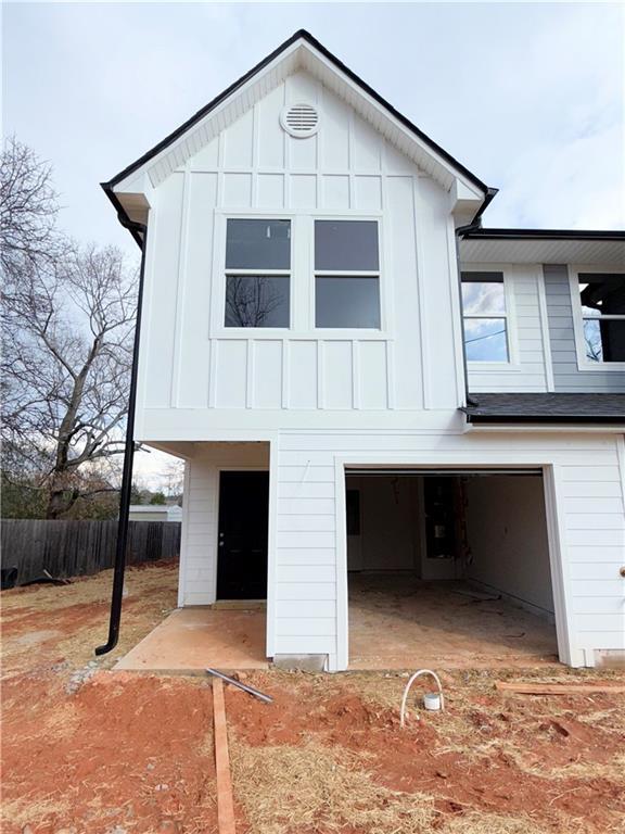 view of front of property featuring board and batten siding, an attached garage, and fence