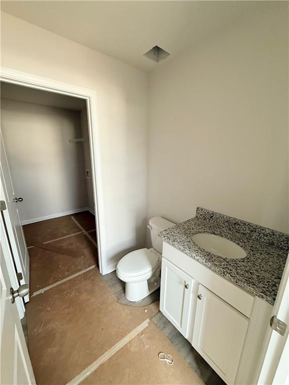 half bath featuring toilet and vanity