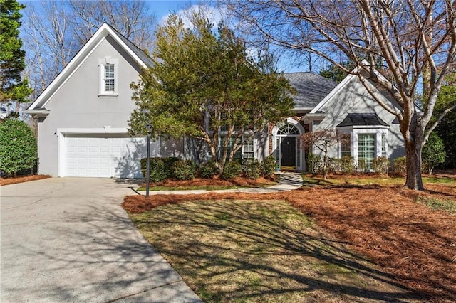 view of front of home featuring concrete driveway, a garage, roof with shingles, and stucco siding