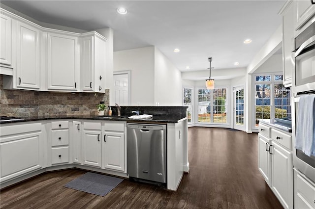 kitchen with stainless steel appliances, tasteful backsplash, dark wood-style flooring, and white cabinetry