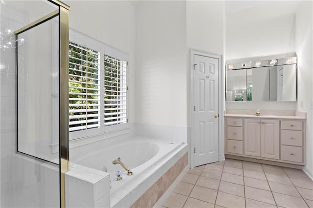 full bath featuring a garden tub, a stall shower, vanity, and tile patterned flooring