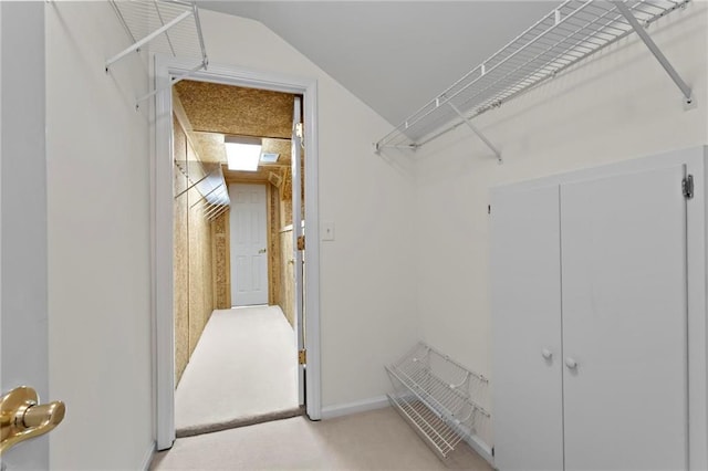 spacious closet with lofted ceiling and light carpet