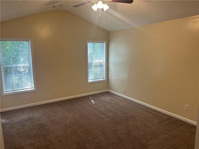 5000 Saxony Ct, Stone Mountain, GA 30083 - spare room with a ceiling fan, vaulted ceiling, dark colored carpet, and a textured ceiling