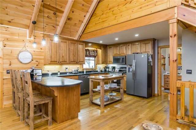 105 Ranch Mountain Ct, Dahlonega, GA 30533 - kitchen with appliances with stainless steel finishes, dark countertops, a peninsula, brown cabinetry, and light wood-style floors