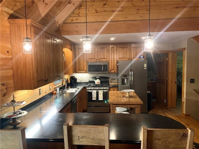 105 Ranch Mountain Ct, Dahlonega, GA 30533 - kitchen with stainless steel appliances, a sink, brown cabinets, decorative light fixtures, and lofted ceiling