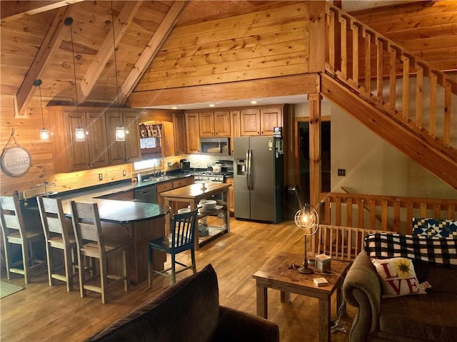 105 Ranch Mountain Ct, Dahlonega, GA 30533 - kitchen featuring appliances with stainless steel finishes, wood ceiling, light wood-type flooring, a peninsula, and brown cabinetry