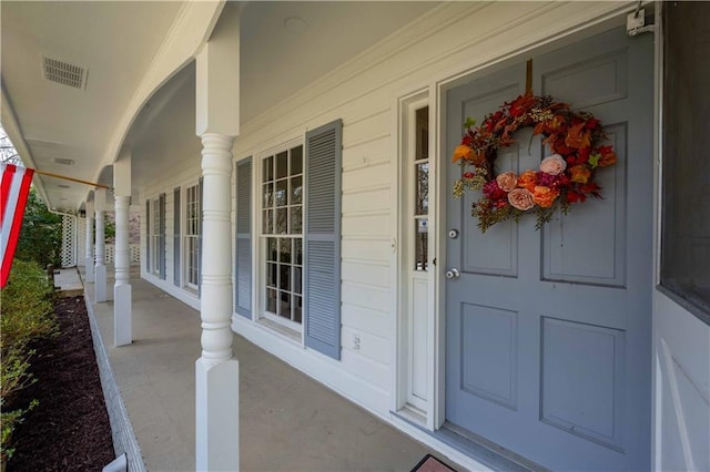 doorway to property with covered porch and visible vents