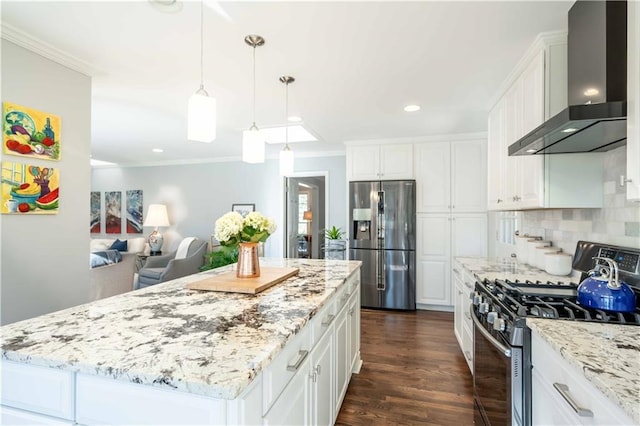 kitchen featuring tasteful backsplash, white cabinets, stainless steel appliances, crown molding, and wall chimney range hood