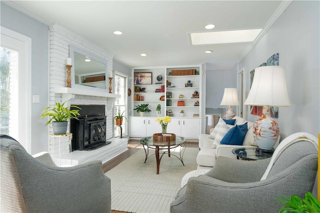 living room with a skylight, crown molding, recessed lighting, a brick fireplace, and wood finished floors