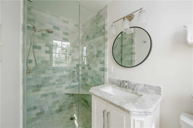 full bathroom with toilet, a shower stall, and vanity