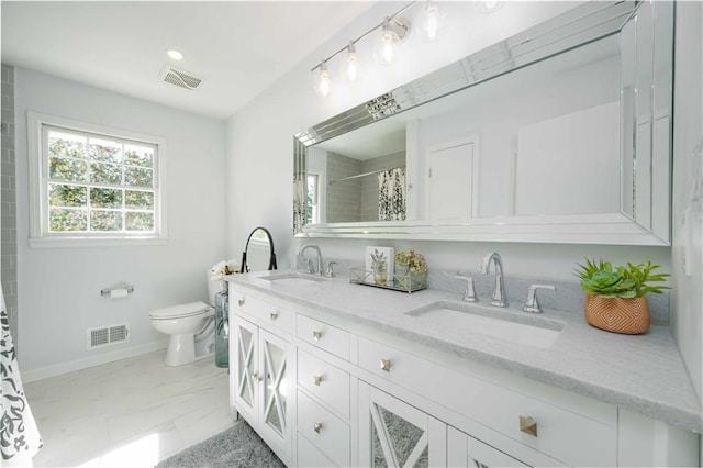 bathroom with toilet, visible vents, and a sink