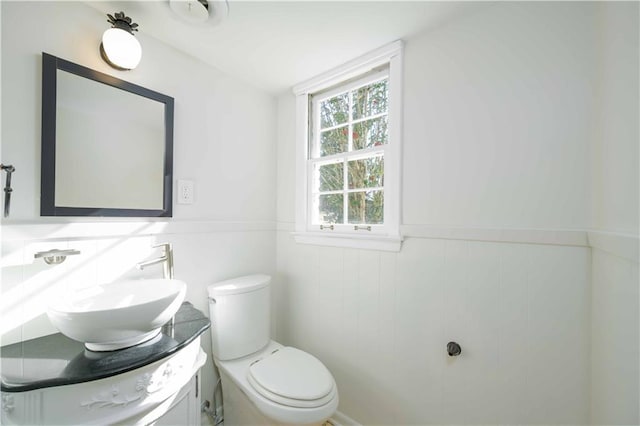 bathroom featuring a wainscoted wall, vanity, and toilet