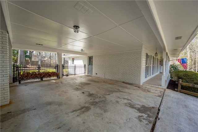 view of patio with a gate, fence, visible vents, and a carport