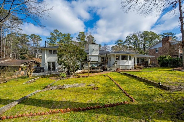 back of house with a lawn and fence