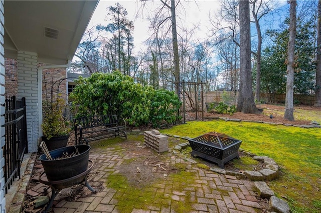 view of yard with a patio area, fence, and a fire pit