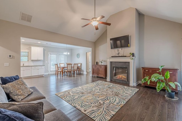 living room featuring ceiling fan, high vaulted ceiling, and dark hardwood / wood-style flooring