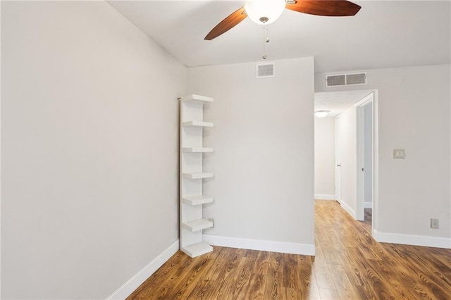 empty room with ceiling fan and hardwood / wood-style floors