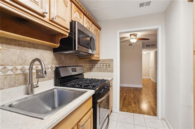 kitchen featuring appliances with stainless steel finishes, tasteful backsplash, ceiling fan, sink, and light tile patterned floors