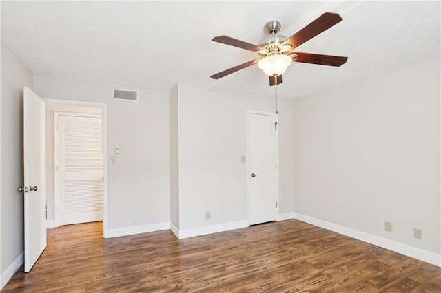 spare room with ceiling fan and dark wood-type flooring