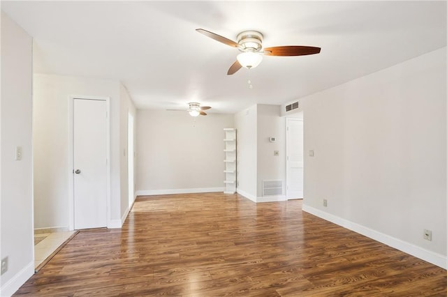 spare room featuring ceiling fan and dark hardwood / wood-style flooring