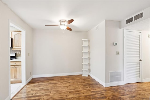 unfurnished room with ceiling fan and dark hardwood / wood-style floors