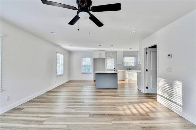 2502 Tupelo St SE, Atlanta, GA 30317 - unfurnished living room featuring a sink, light wood-style floors, ceiling fan, and baseboards