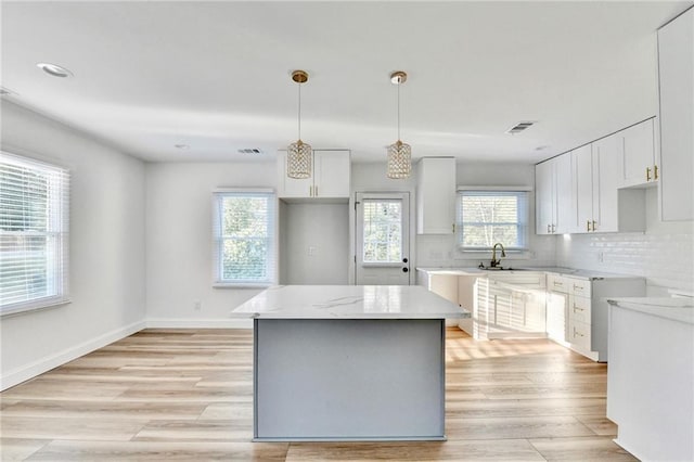 2502 Tupelo St SE, Atlanta, GA 30317 - kitchen with backsplash, light wood-style flooring, white cabinets, a sink, and recessed lighting